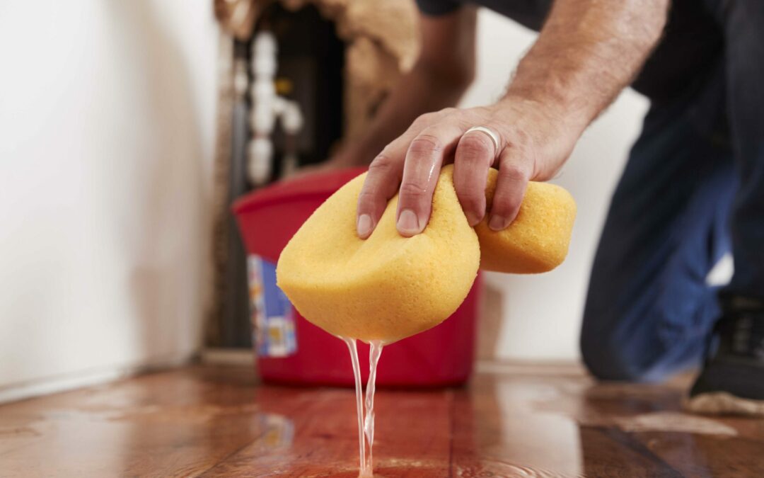man mopping up water after his HVAC unit leaked