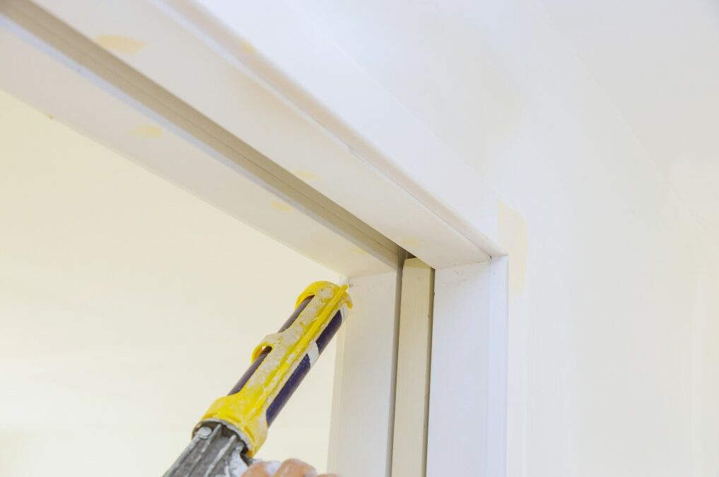 A Caulk Gun Being Used to Seal a House